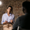 Attractive woman giving an interview in a studio, gesturing with his hands while she is talking